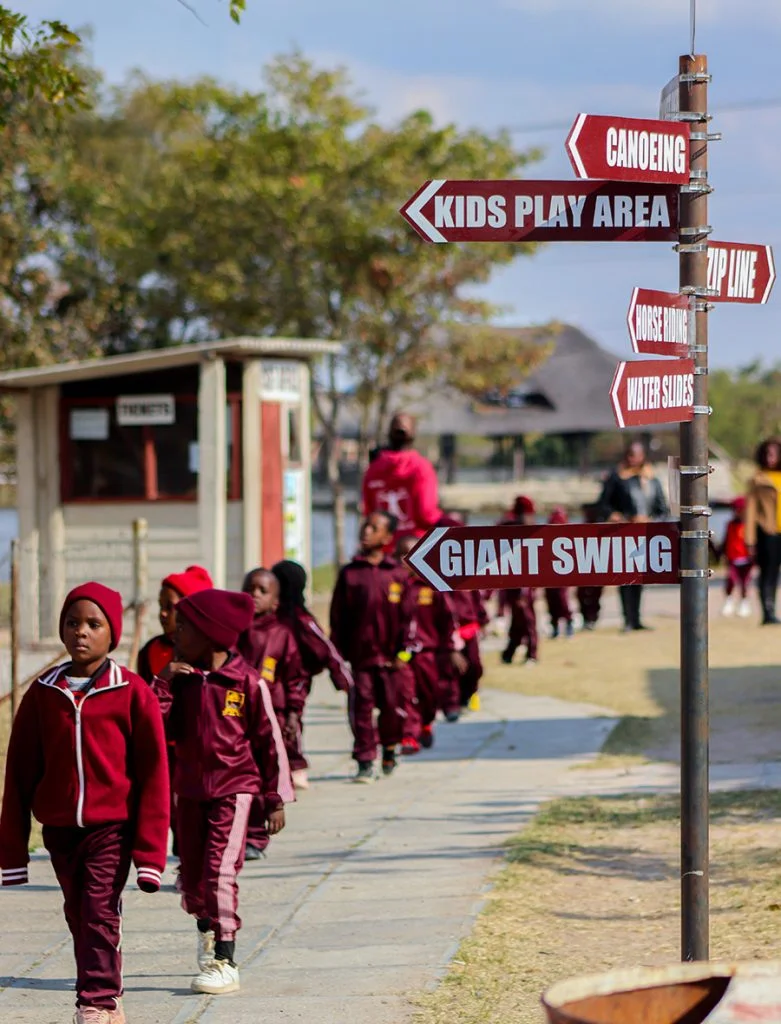 School children walking past resort signpost
